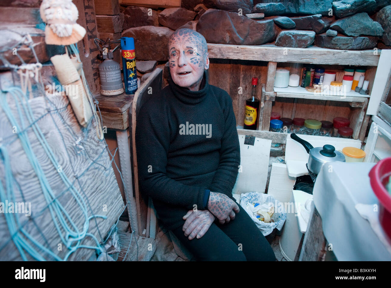 L'ermite tatoué Tom Leppard (aka Leopard Man) à l'aise dans son refuge secret cachette souterraine de fortune de Skye, en Ecosse Banque D'Images