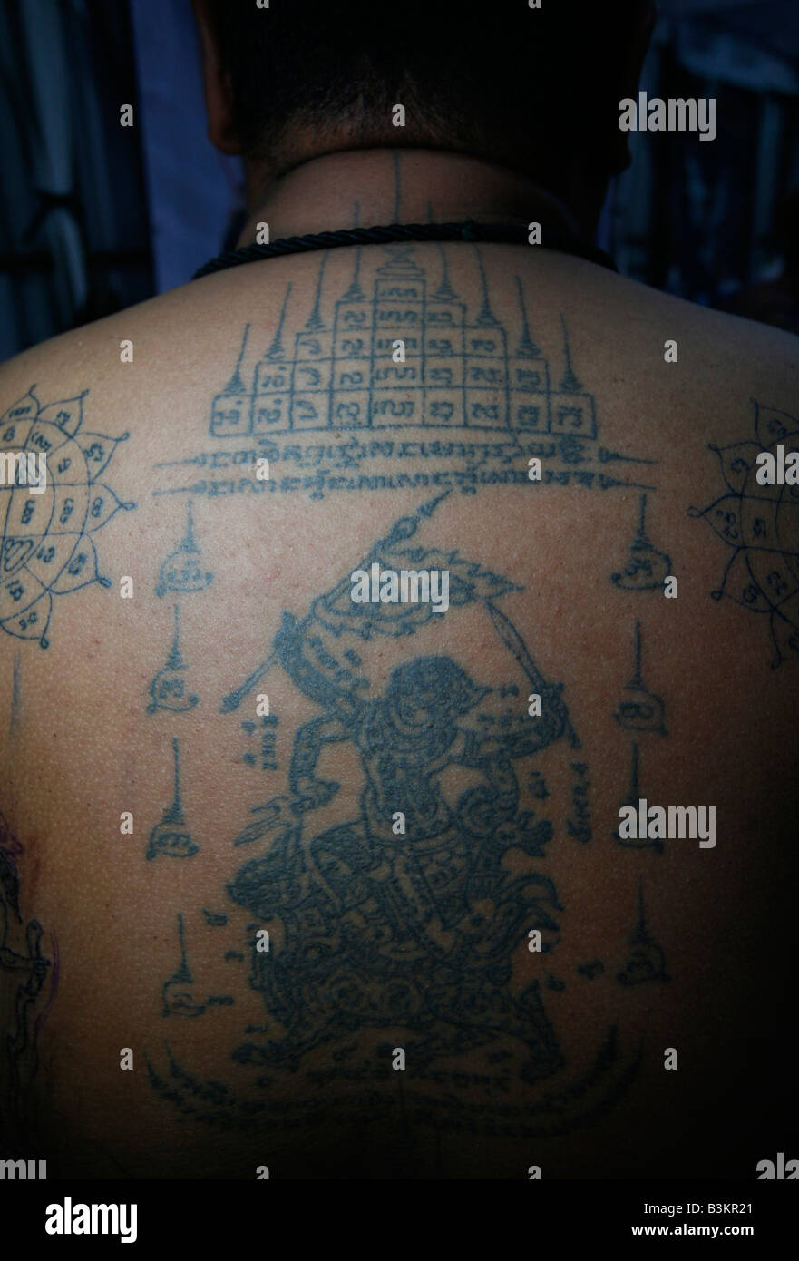 Les symboles religieux sont tatoués sur un homme est de retour au Festival International Tattoo à Pattaya en Thaïlande. Banque D'Images