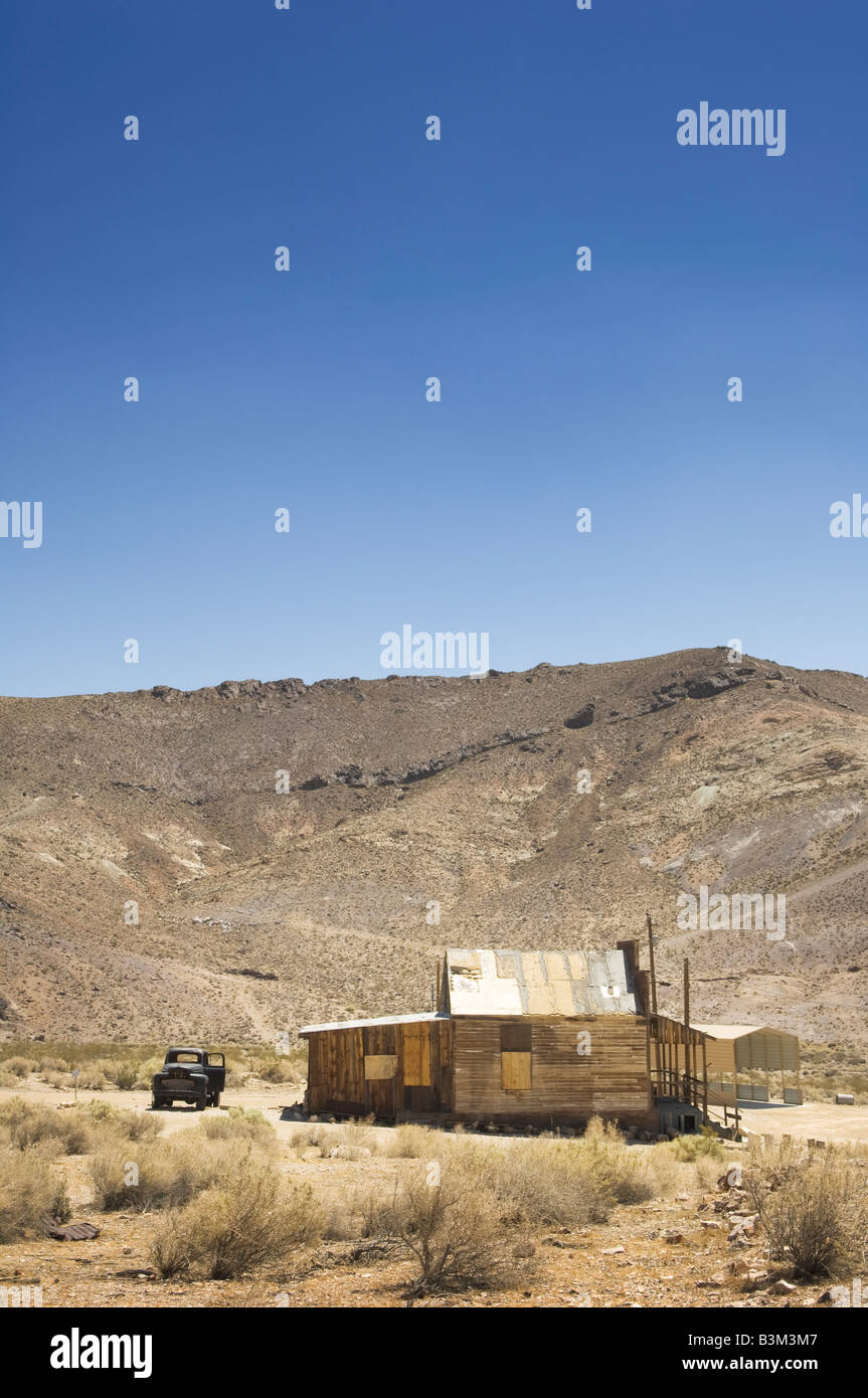Maison à l'abandon et Rusty noir chariot. Désert du Nevada, USA. Banque D'Images