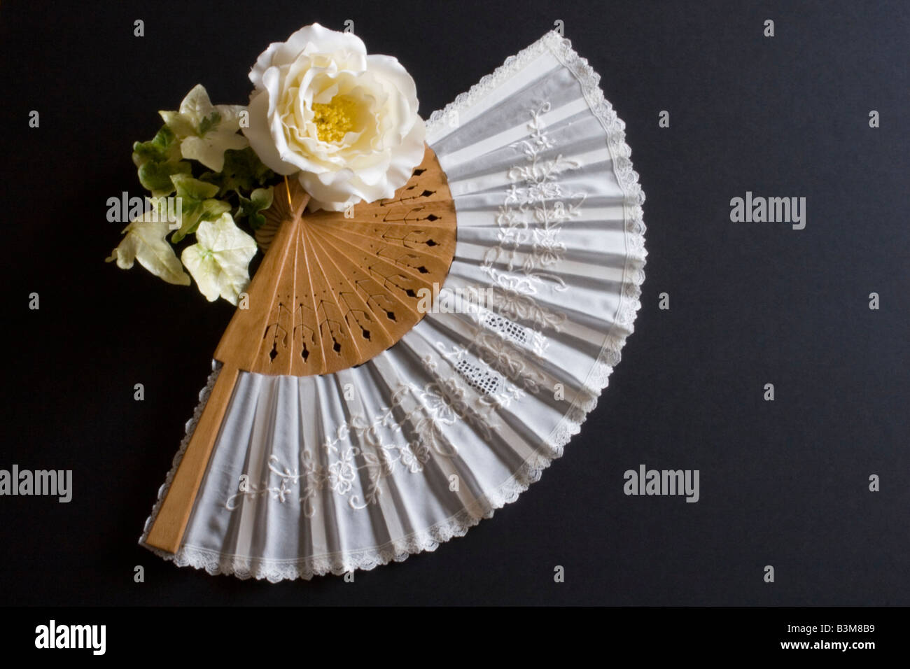 Pliage blanc oriental fan sur un fond noir avec fleur Banque D'Images