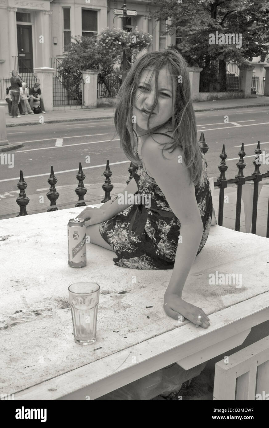Femme ayant un drôle de visage avec une canette de bière et un verre en noir et blanc dans la rue à Londres 2008 Banque D'Images Femme ayant un drôle de visage avec une canette de bière et un verre en noir et blanc dans la rue à Londres 2008 Banque D'Images