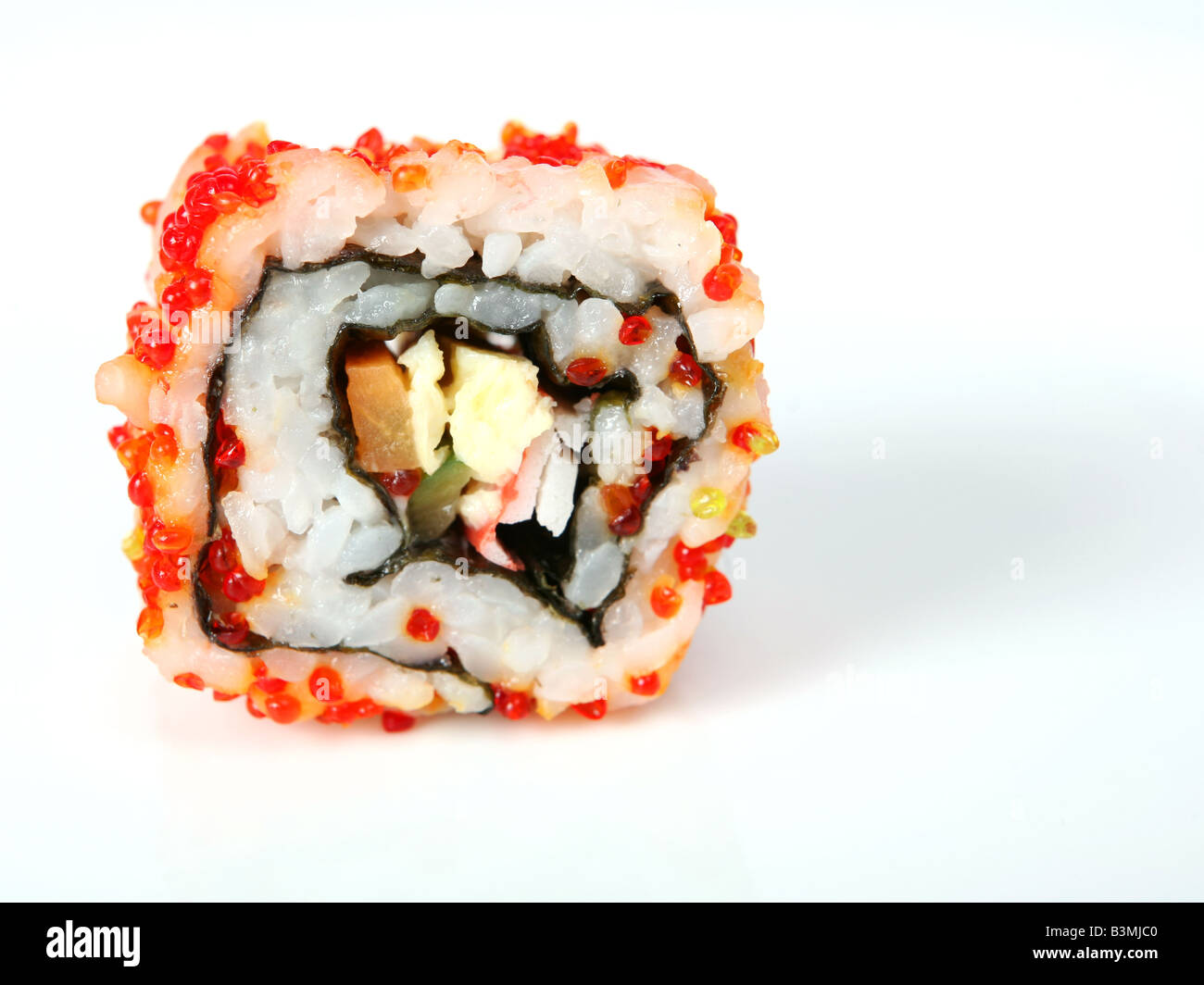 Un rouleau de Californie uramaki sushi avec caviar de couleur sur un fond uni Banque D'Images