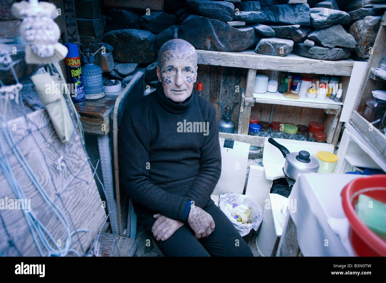 L'ermite tatoué Tom Leppard (aka Leopard Man) à l'aise dans son refuge secret cachette souterraine de fortune de Skye, en Ecosse Banque D'Images