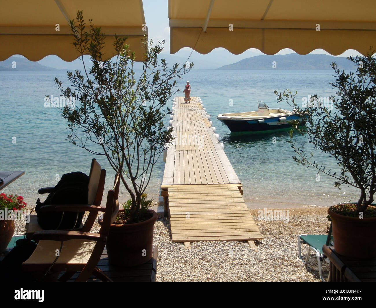 Jetée à l'Agni pittoresque plage, en face de taverna. Île de Corfou, Grèce. Banque D'Images