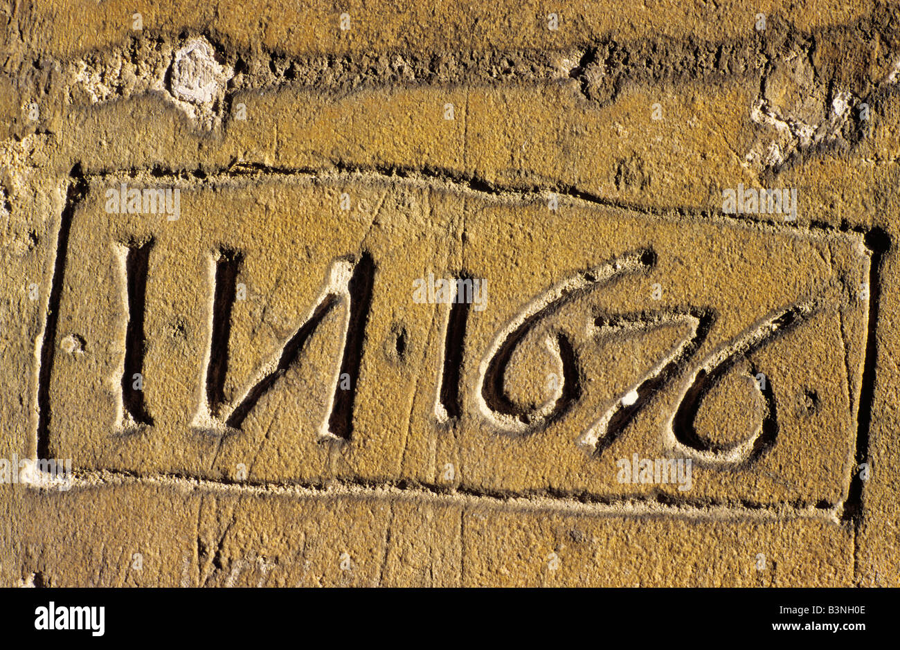 Graffitti 17e siècle gravées les initiales gravées sur le mur de l'église de Norfolk d'Angleterre UK 1676 date Banque D'Images