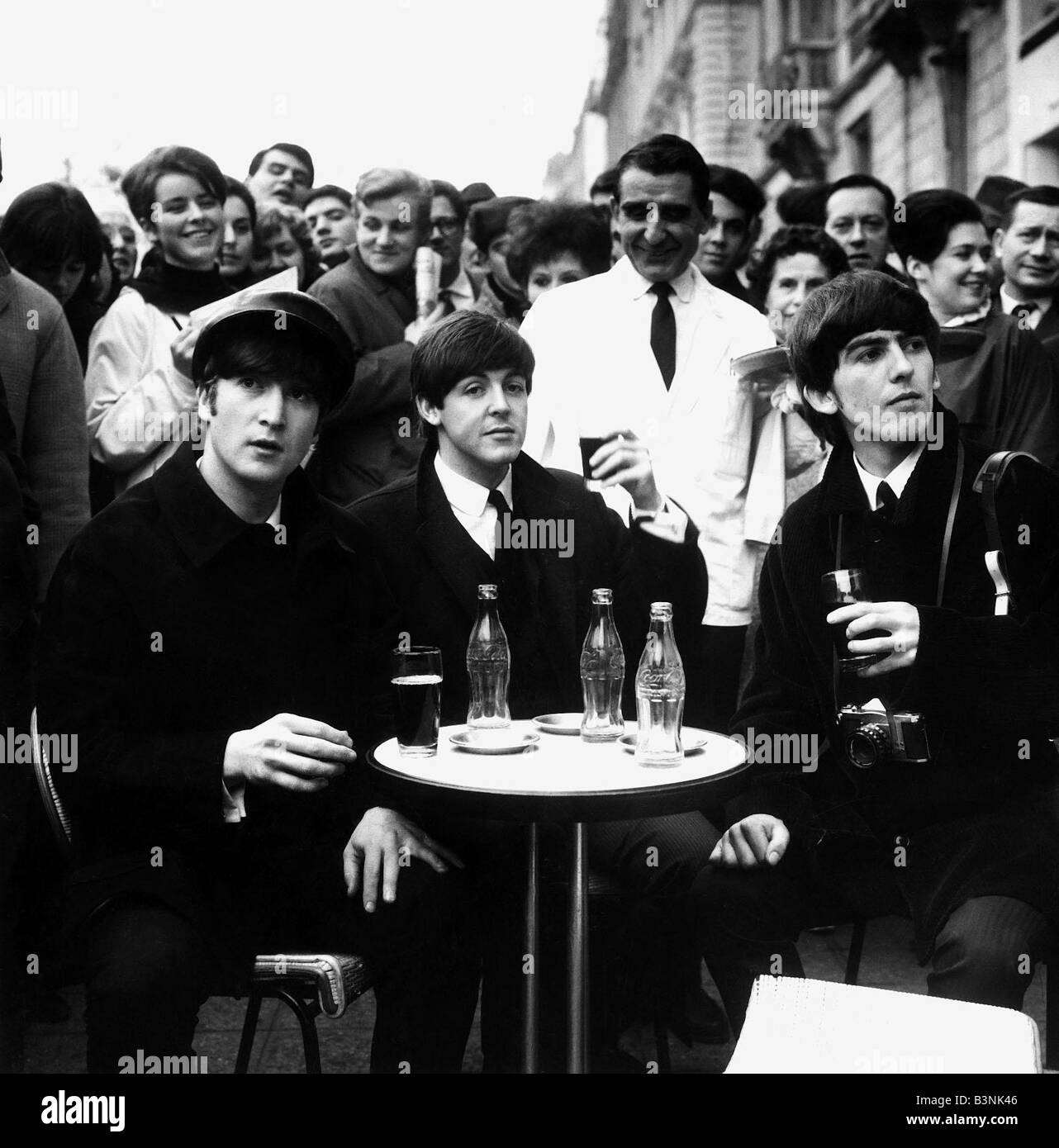 John Lennon, Paul McCartney et George Harrison des Beatles de déguster une boisson à un outdoore cafe in Paris France Janvier 1964 Banque D'Images John Lennon, Paul McCartney et George Harrison des Beatles de déguster une boisson à un outdoore cafe in Paris France Janvier 1964 Banque D'Images