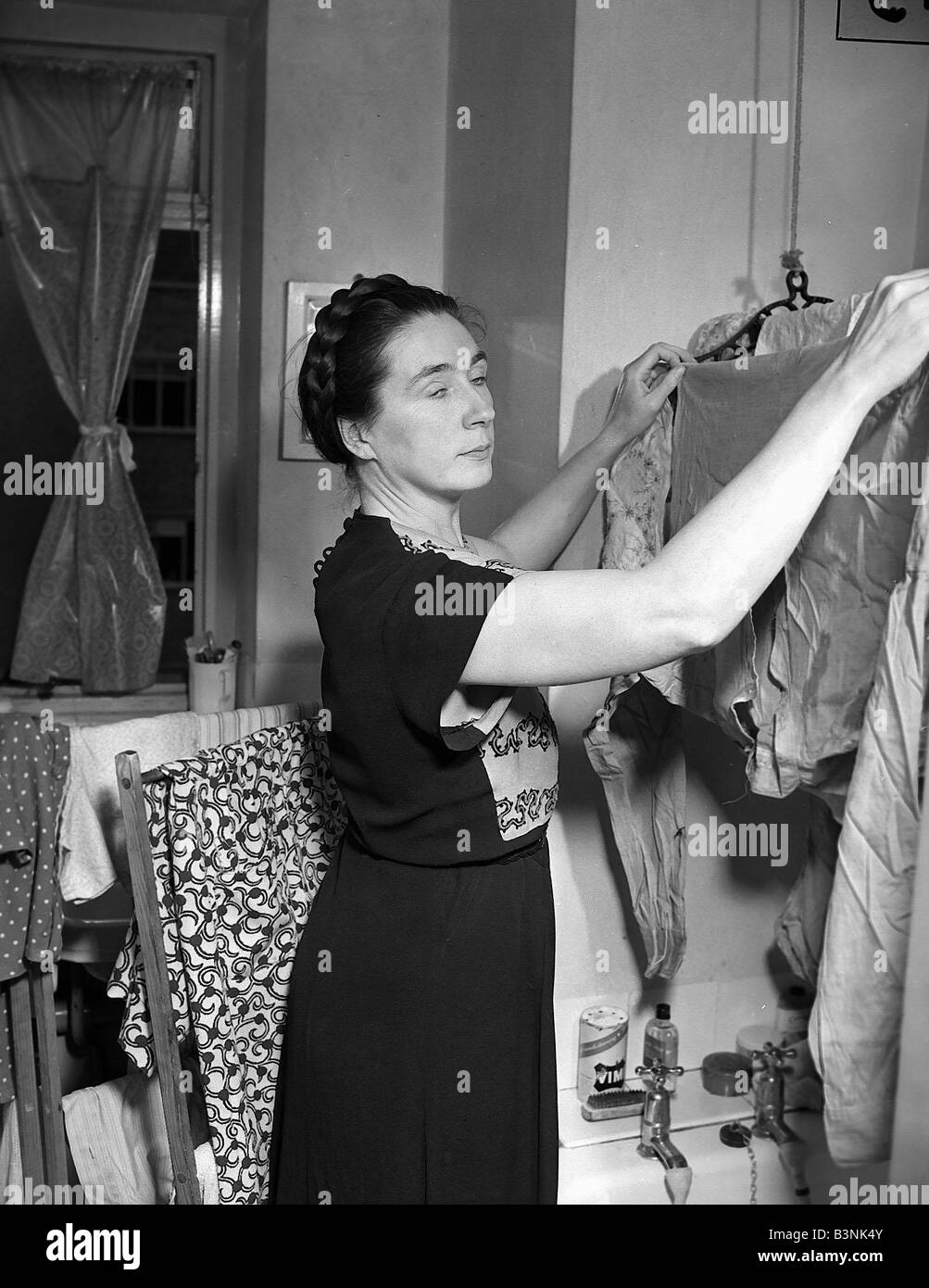 Housewives lave-controverse Woman hanging up vêtements à sécher dans son North Kensington accueil Mai 1952 Mirrorpix Banque D'Images