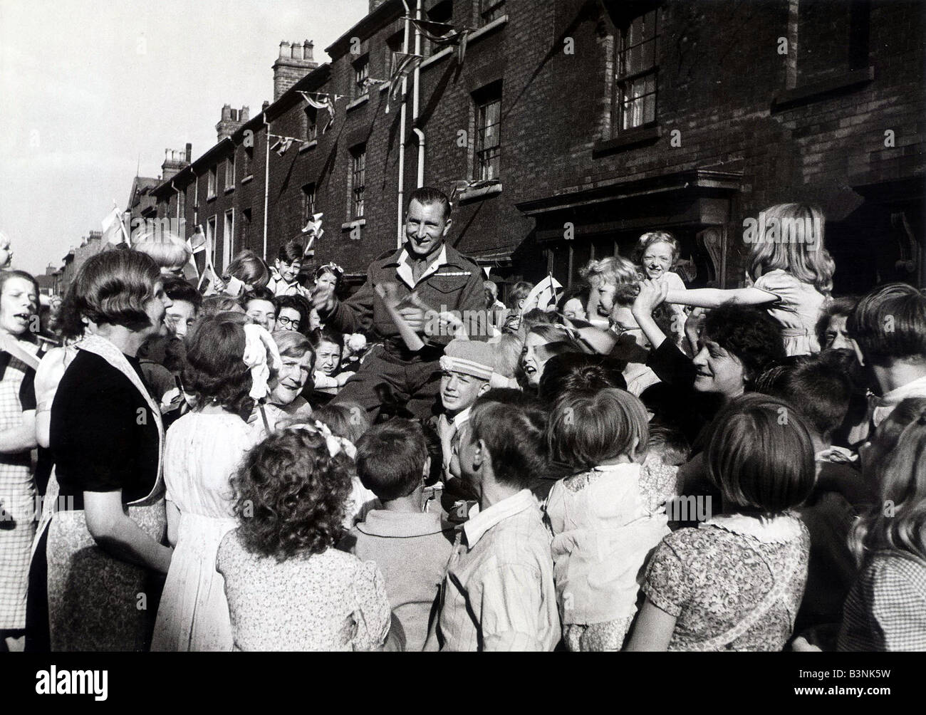 30 ans de Jim privé Kavangh Edward Street Birmingham ne pouvaient pas retourner chez eux pour le jour de la victoire de sorte que les enfants ont attendu jusqu'à ce qu'il n'a retourner avant d'avoir leur célébration de la journée de la paix Août 1945 Banque D'Images