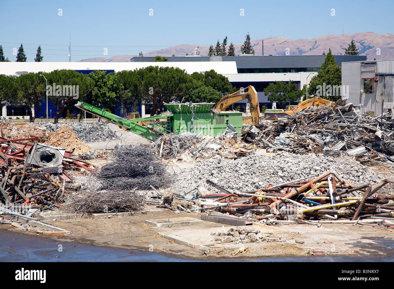 Demoliton moud machines pour le recyclage des débris jusqu'à un bâtiment commercial déchirer vers le bas. Banque D'Images