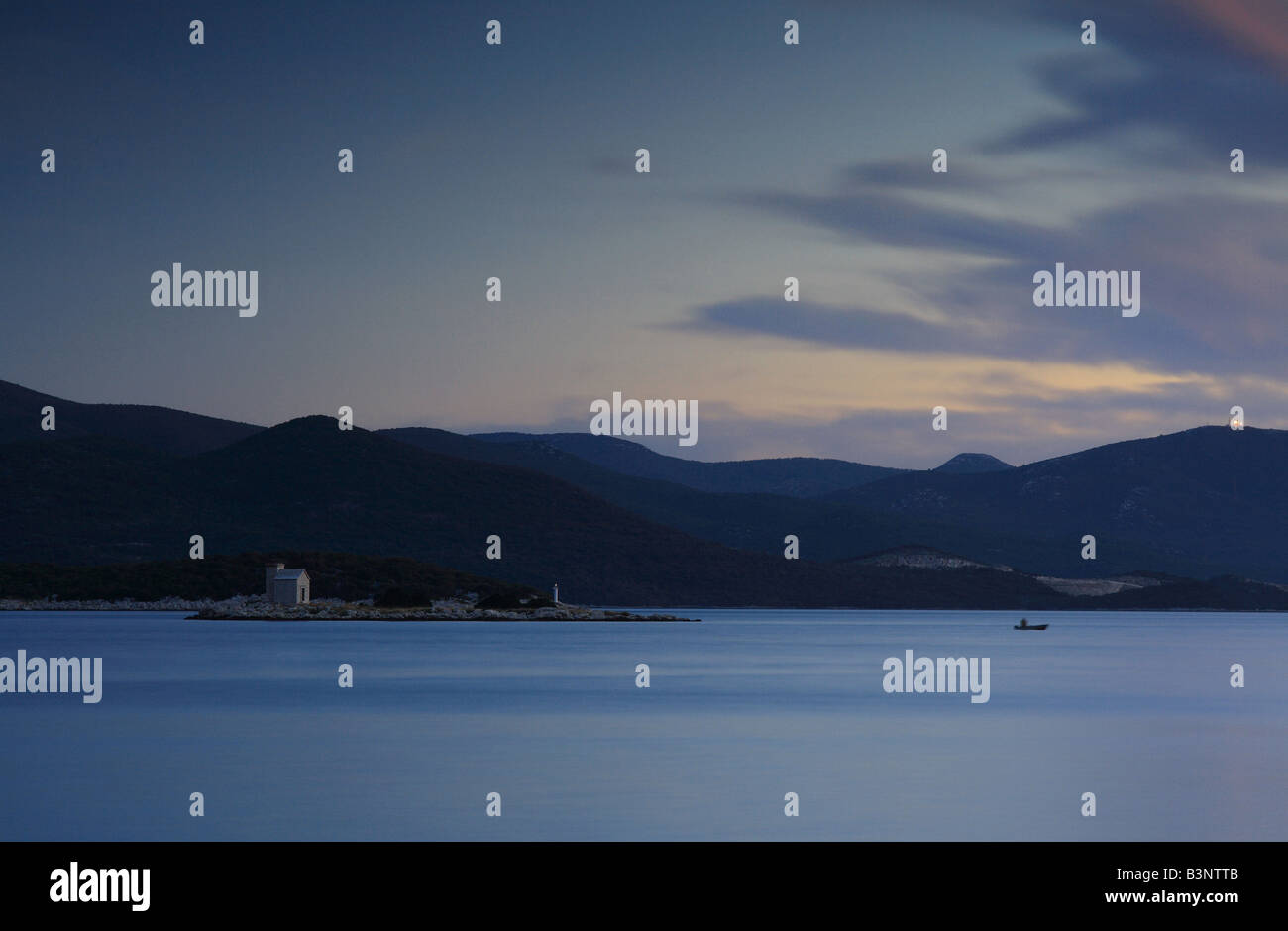 Coucher de soleil sur le golfe près de Sibenik, Croatie, avec une vue vers la petite île avec la maison blanche Banque D'Images