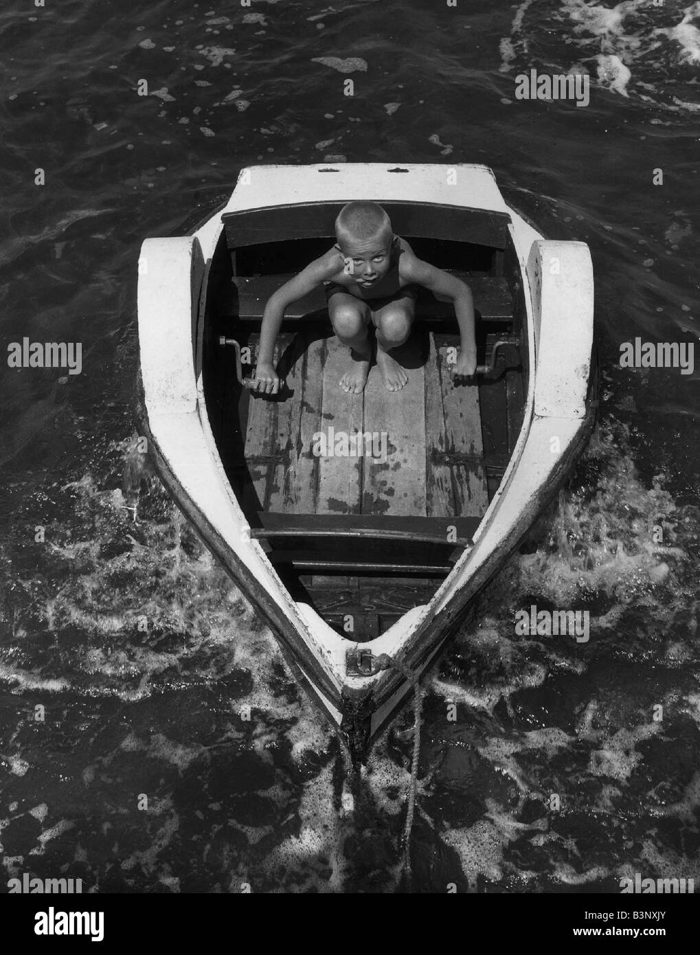 Les jeunes peu Keith voiles de Chelmsford, dans son bateau à aubes maison de vacances bord de mer Enfance Sticking out tongue Août 1963 AfairScenes Banque D'Images