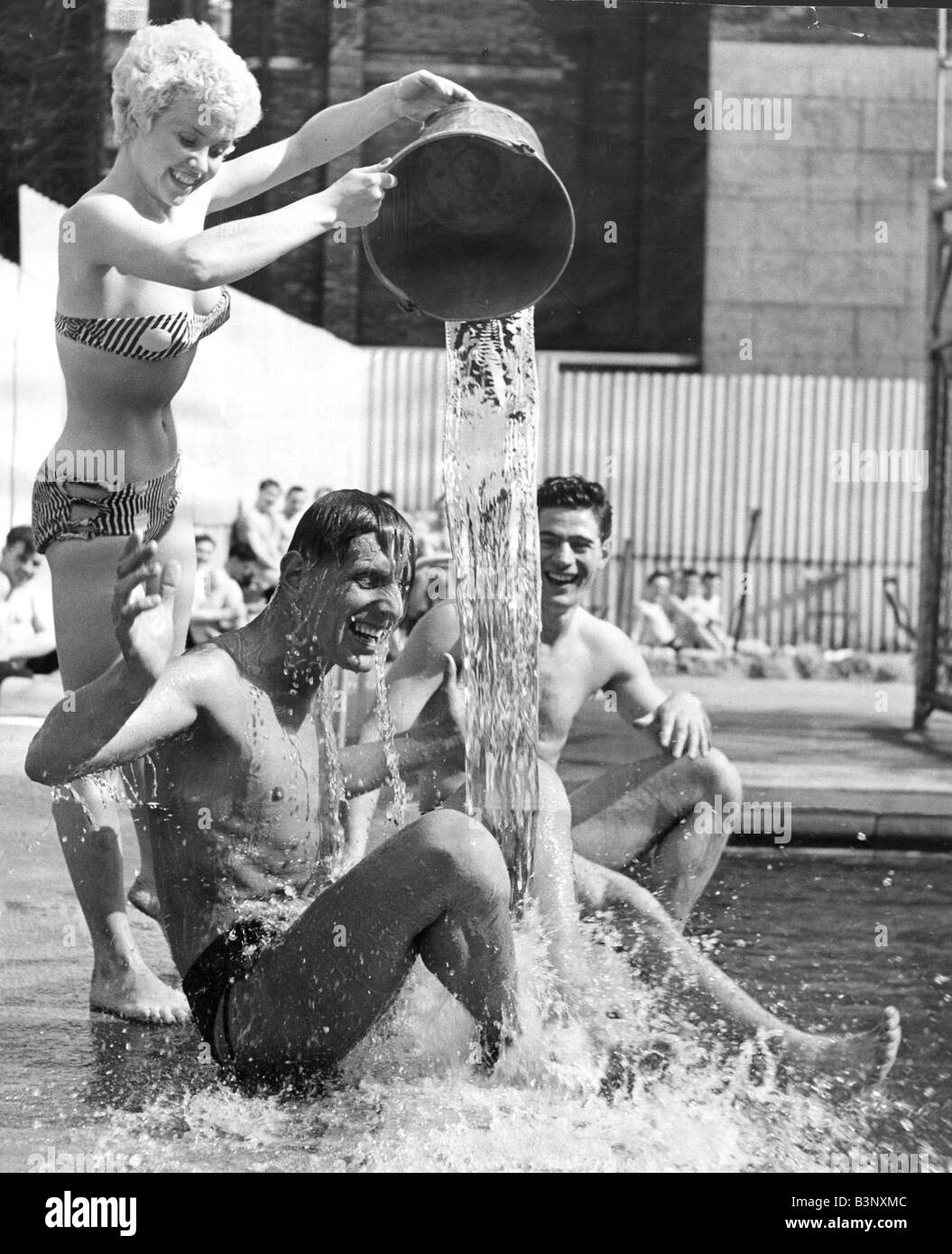 Une façon de vous rafraîchir dans la vague de chaleur actuelle est d'avoir un seau d'eau froide jetée sur vous, mais quand il est jeté par attractive blonde Vera Day qui se soucie certainement Jack White ne Mai 1954 Banque D'Images