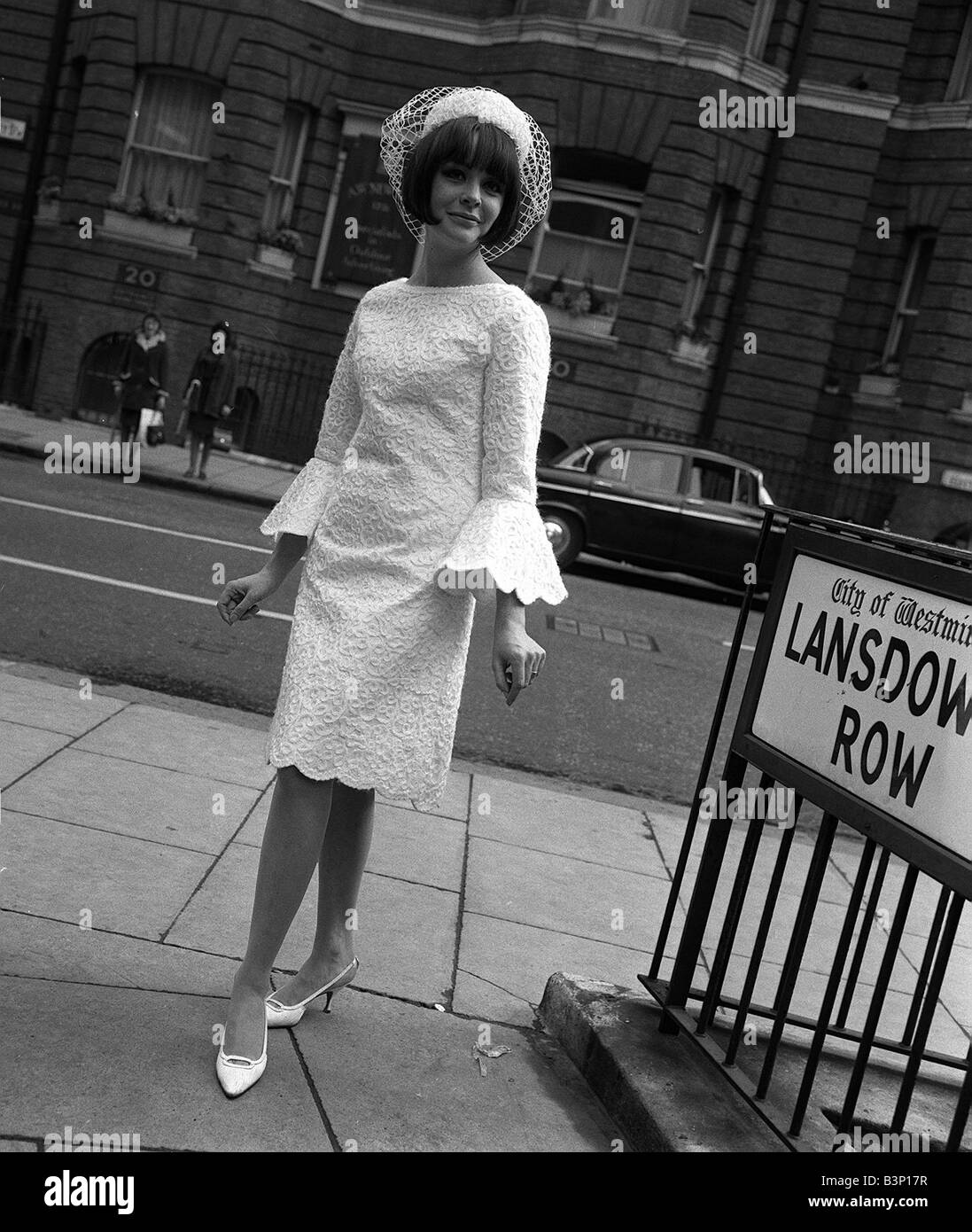 La mode des années 60 par Kiki Byrne wearinf modèle robe blanche avec des  manches larges et un chapeau blanc sur le carrefour de Lansdown Photo Stock  - Alamy