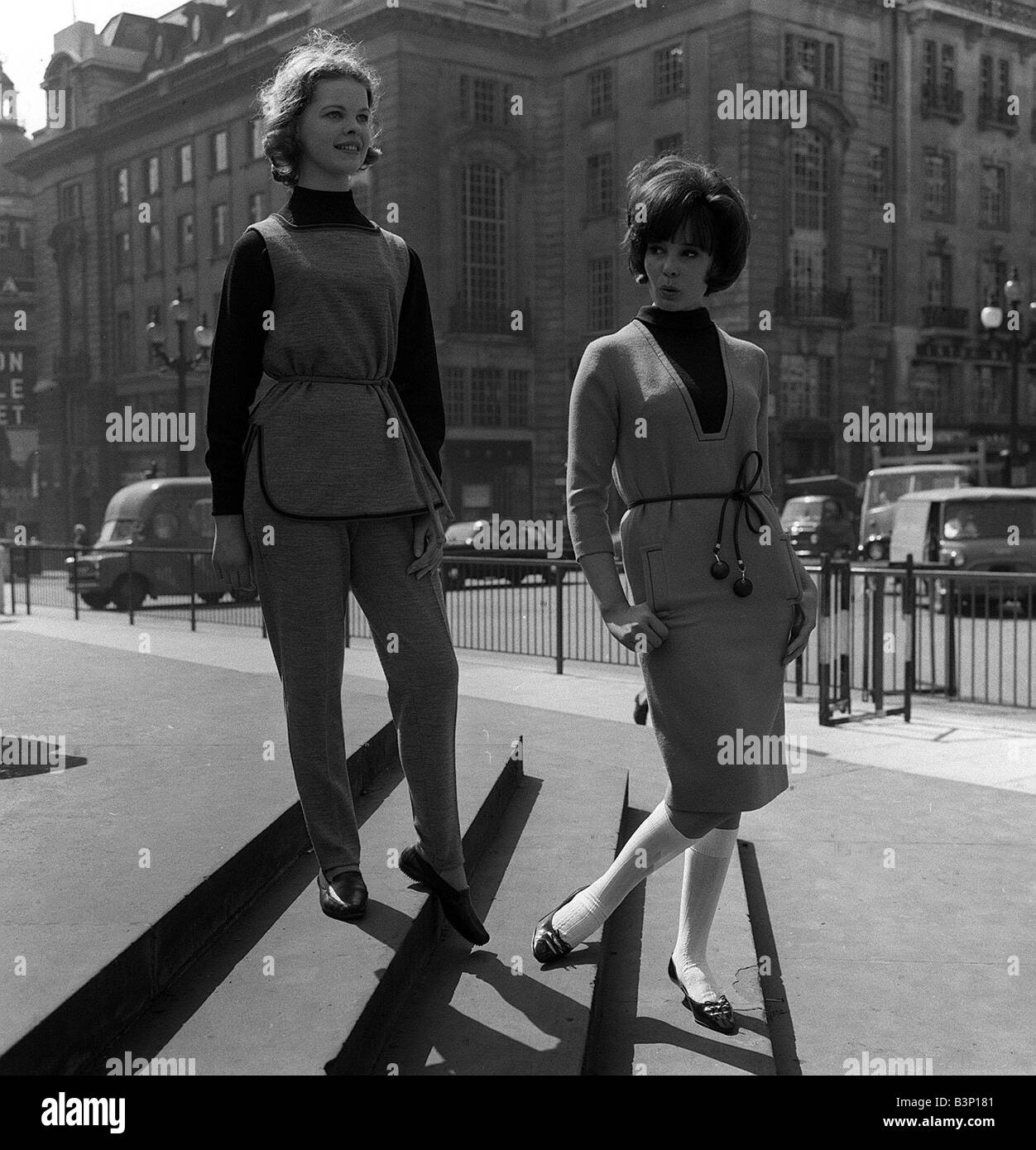 La mode chez les adolescentes dans les années 60, deux jeunes filles debout  sur mesures dans la rue l'un porte une tunique et un pantalon et l'autre  est en jupe et veste