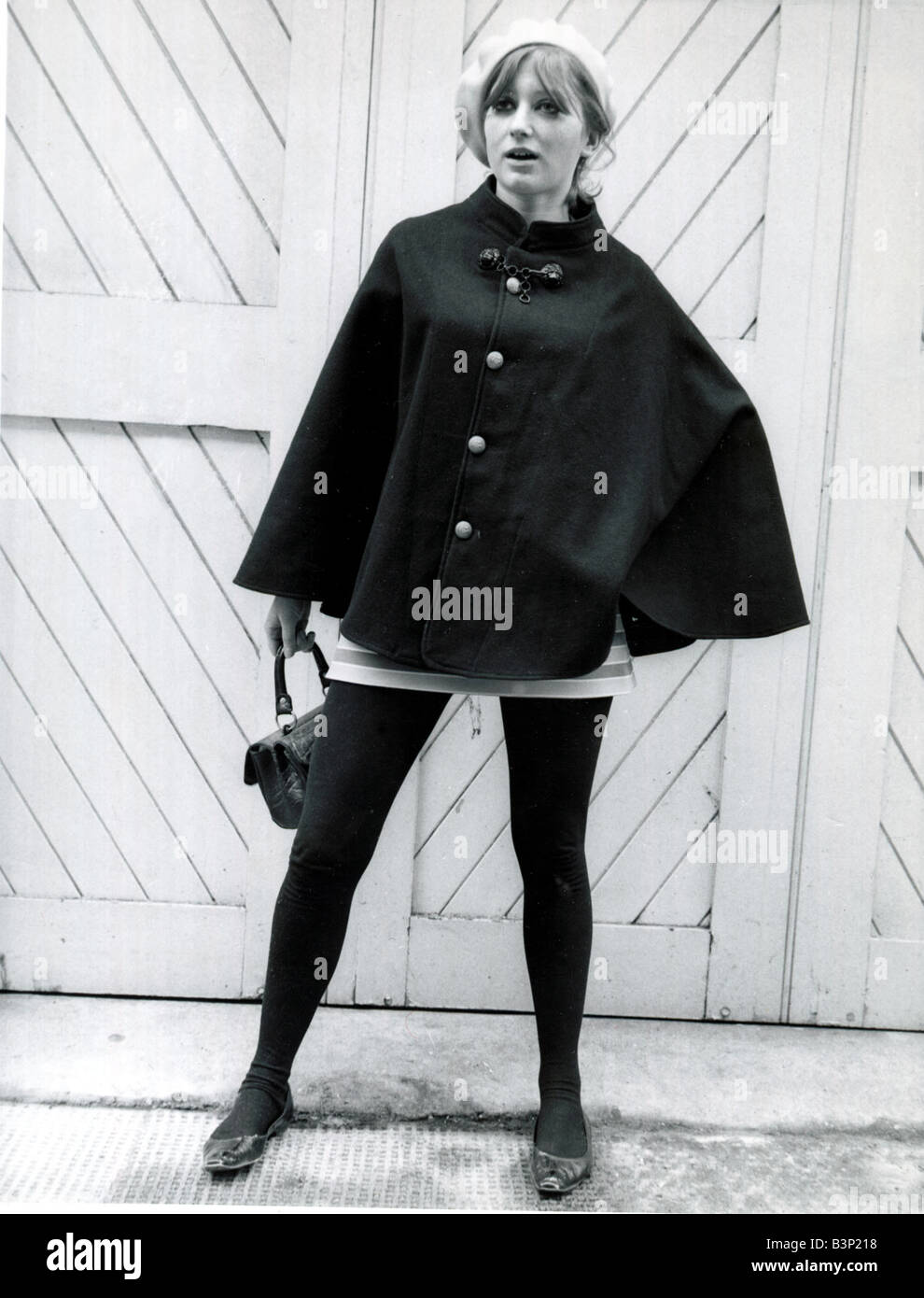 La mode des années 60 s modèle portant un béret et cape noir rayé blanc  mini jupe avec collants noirs et des chaussures tenant un sac à main Photo  Stock - Alamy
