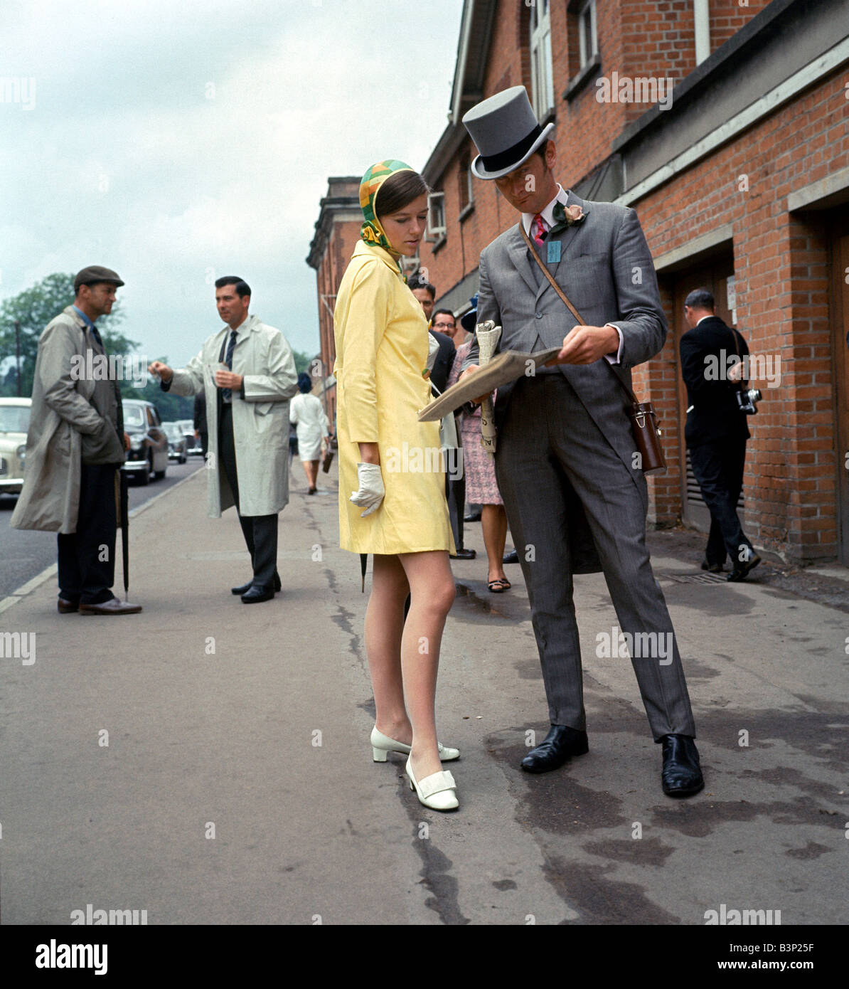 La mode des années 60 années 60 Vêtements Femme en jaune orange et vert  robe à motifs Homme en haut de forme et queue Photo Stock - Alamy