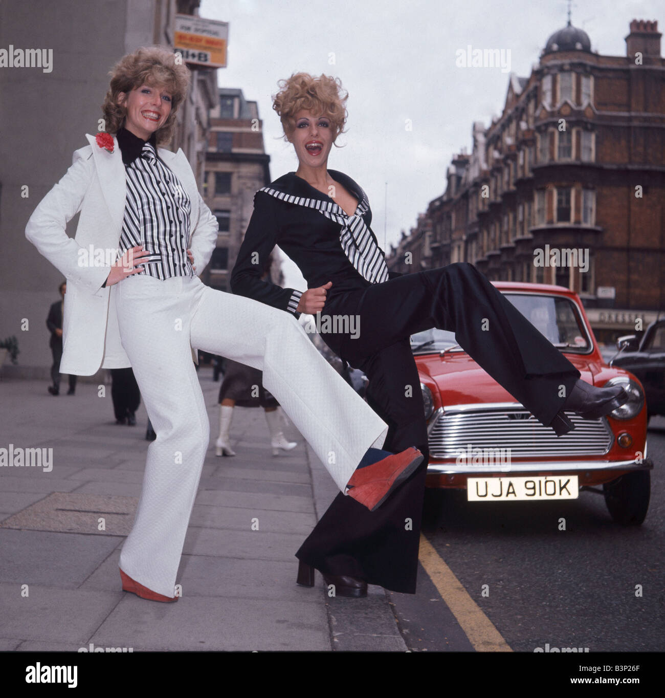 La mode des vêtements de Glasgow 1972;Costume marin v 'false' abatteur poursuite par Elgee;Deux femmes debout dans la rue à coups de pied avec une jambe debout avec leurs mains sur leurs hanches;Mars 1972 ; Banque D'Images