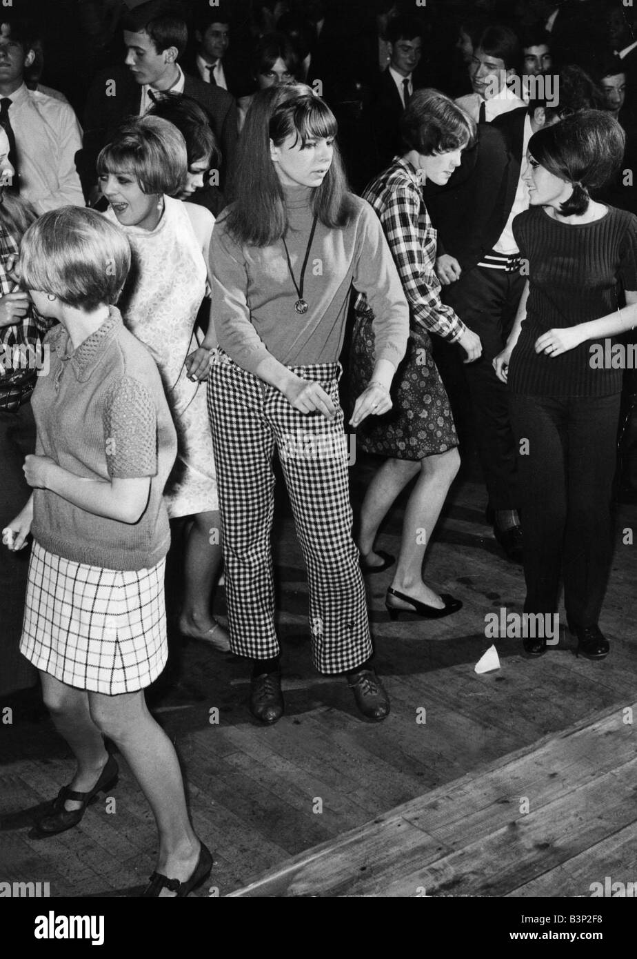 Les adolescents de nouvelles tenues et cavaliers pantalons jupes et robes jeunes s'amuser danser dans une discothèque Banque D'Images