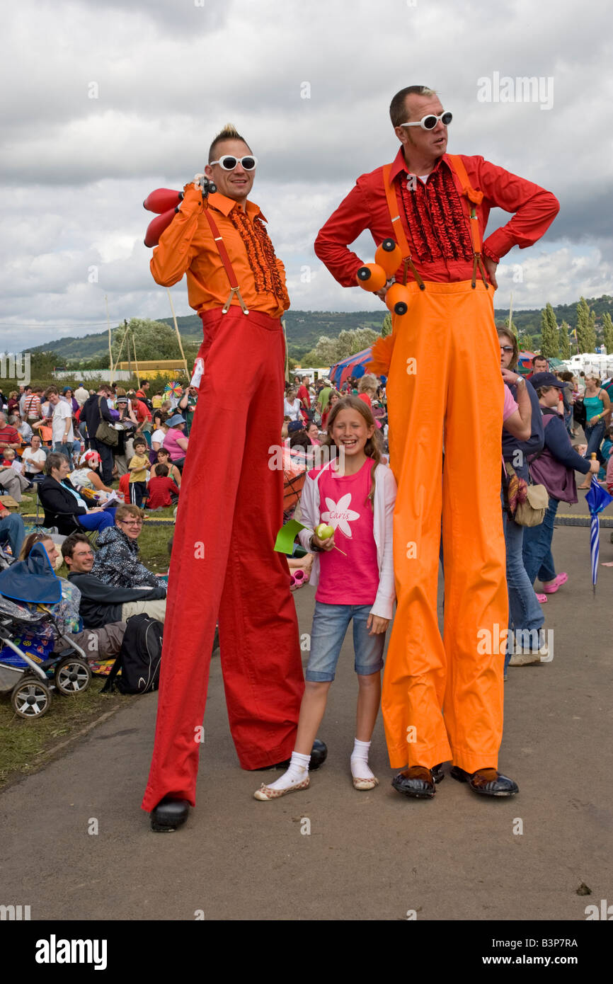 Deux hommes jongleurs sur pilotis avec jeune fille admirateur de verdure 2008 l'Hippodrome de Cheltenham UK Banque D'Images