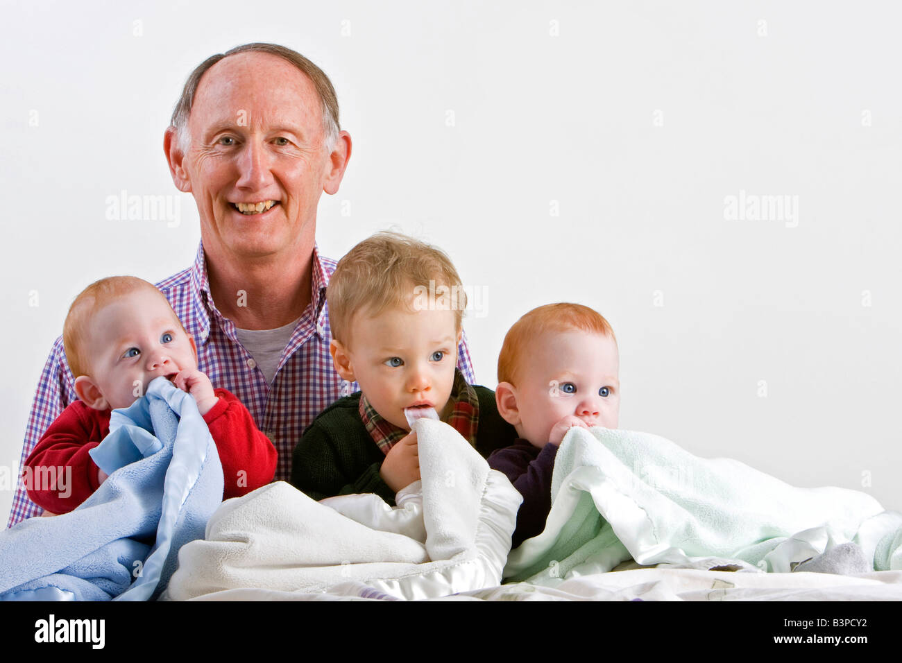 Fier grand-père avec trois petits-fils, y compris pour des jumeaux Banque D'Images