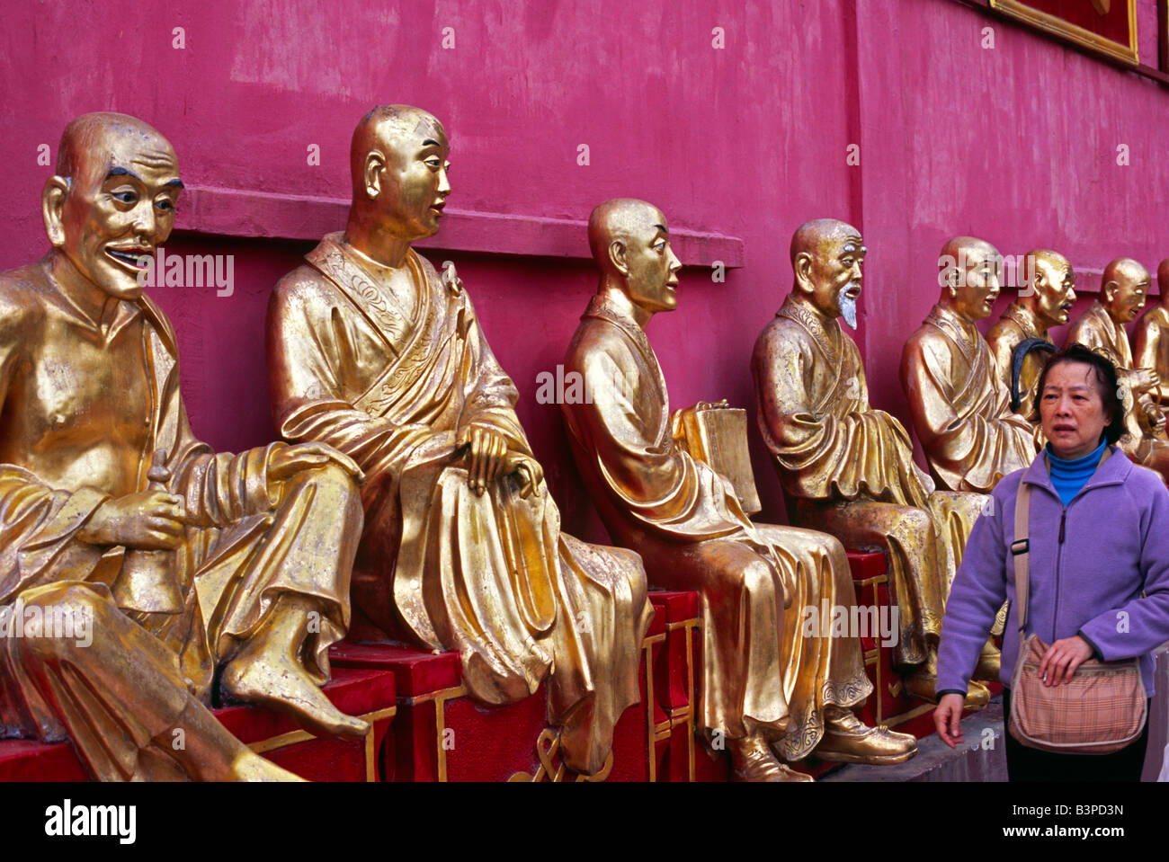 La Chine, Hong Kong, Sha Tin. Une rangée de statues de Bouddha en or à accueille les visiteurs les dix mille bouddhas monastère près de Sha Tin dans Banque D'Images