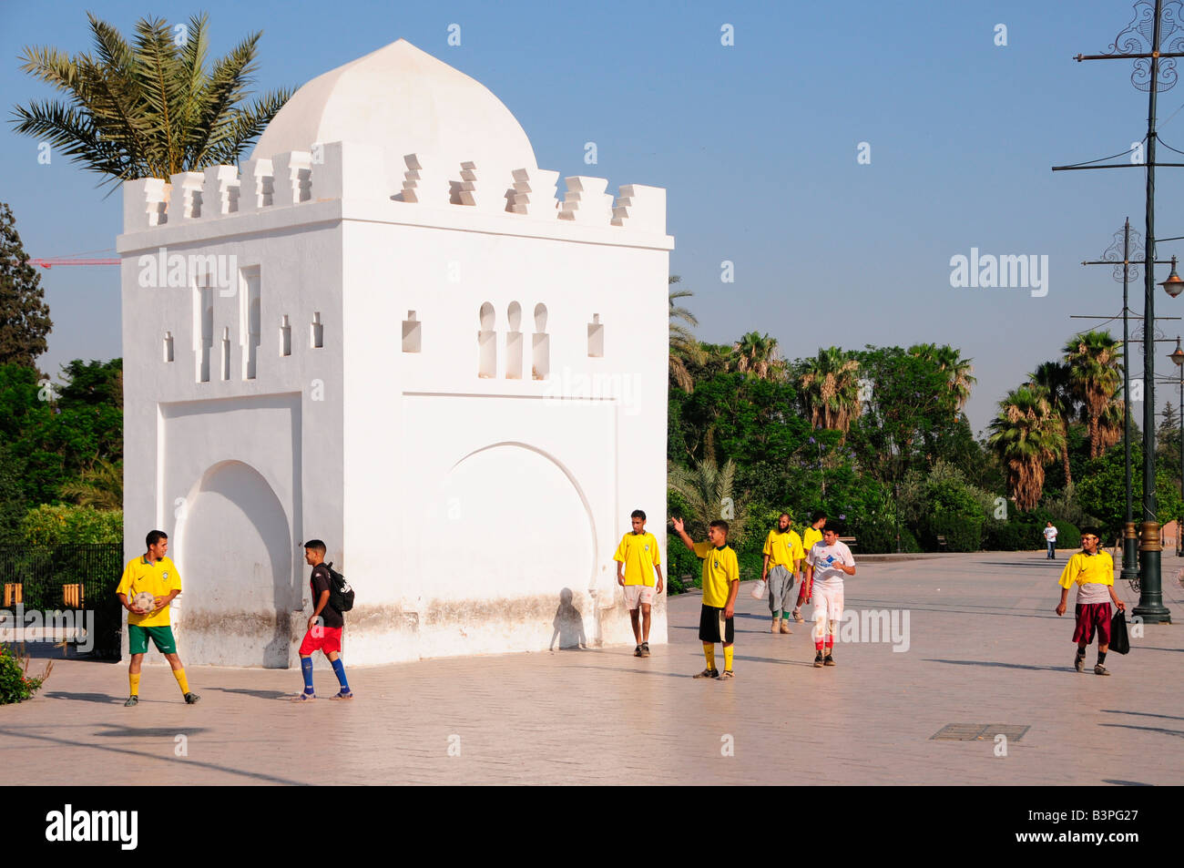 Les enfants portant des maillots de football en face de la petite citadelle de l'Koutoubiya-Mosque, Marrakech, Maroc, Afrique Banque D'Images