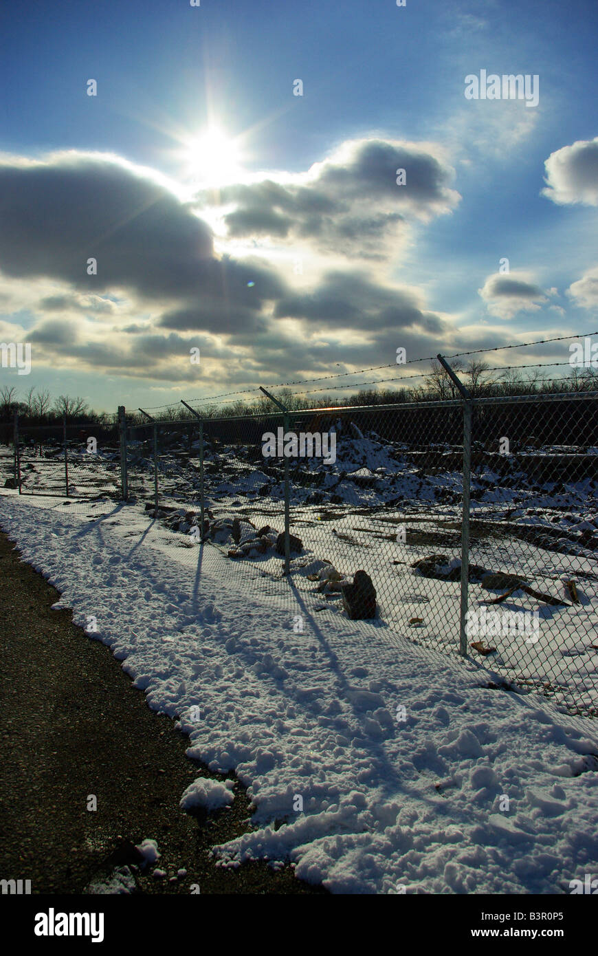 Le livre blanc de l'hiver soleil illumine un paysage enneigé à travers les nuages Banque D'Images