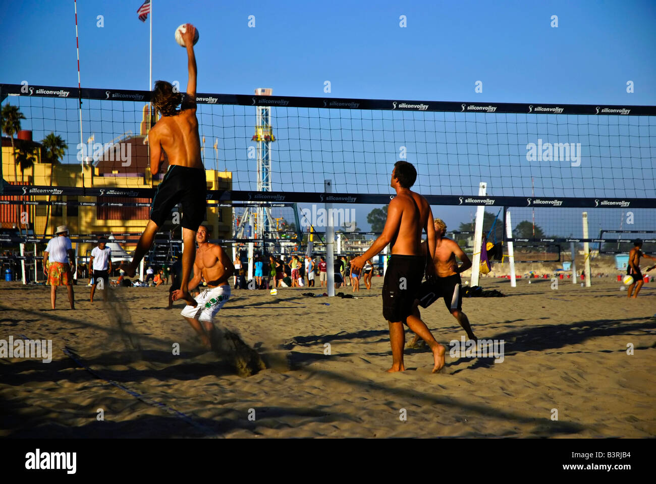 Les jeunes hommes jouant une partie de volley-ball à la plage près de la promenade de Santa Cruz en Californie Banque D'Images