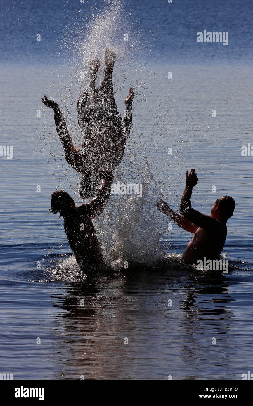 Deer Lake dans le Michigan USA trois garçons frères hommes caucasiens ayant du plaisir à jouer dans le saut d'eau à saut d'eau vertical hi-res Banque D'Images