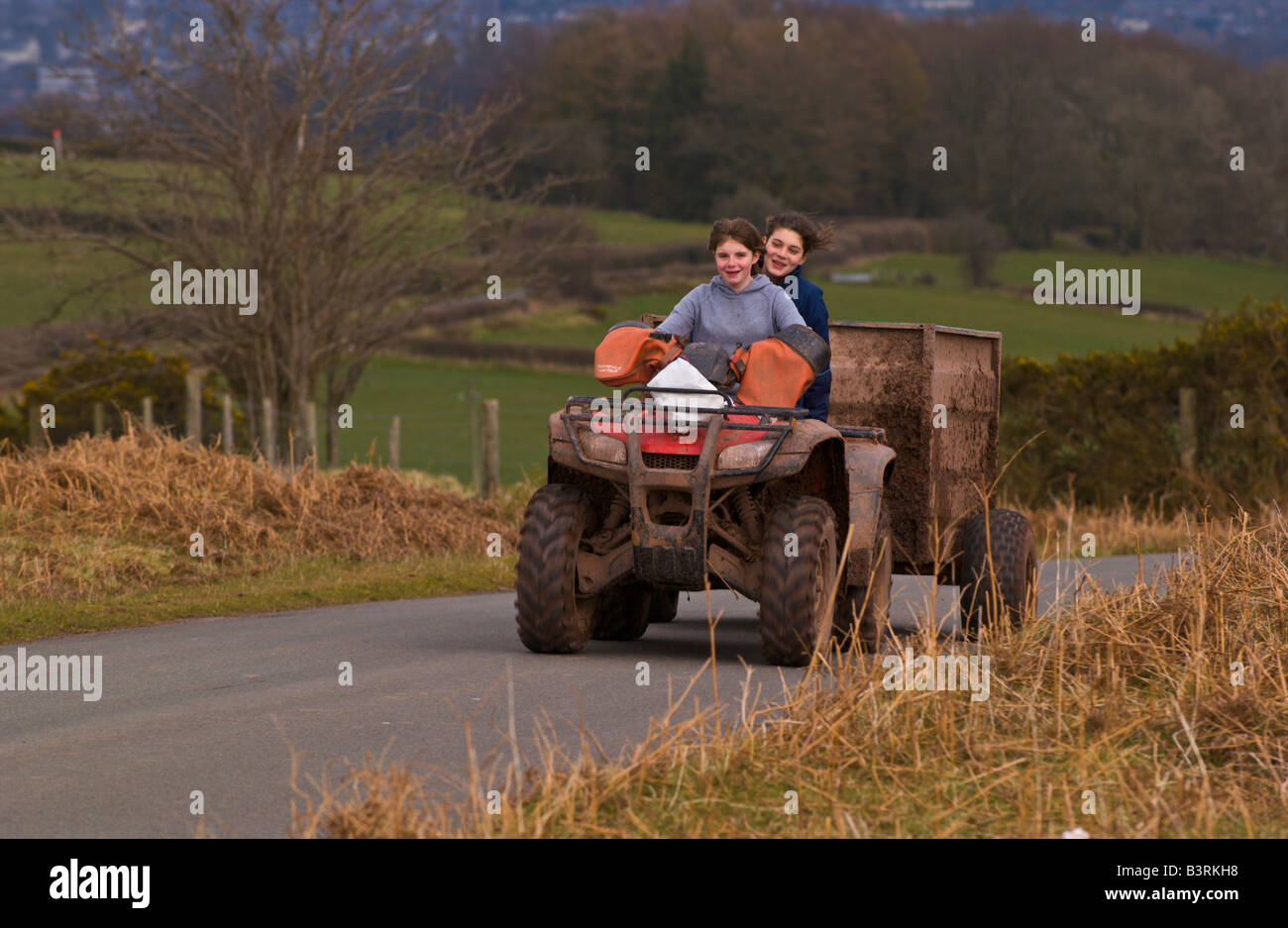 Deux filles de ferme sur quad avec remorque sur Mynydd commun Illtyd près de Brecon Powys Pays de Galles UK Banque D'Images