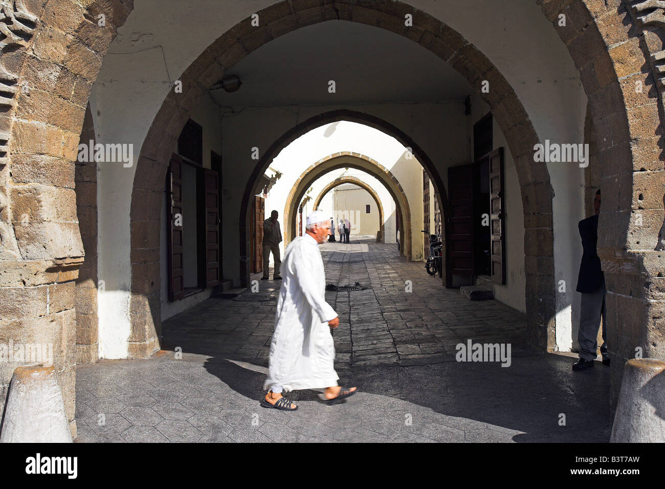 Le Maroc, Maghreb, Casablanca. Un homme marche à travers le Quartier Habous ou 'nouvelle médina'. Construit par les Français dans les années 1930, les architectes ont essayé de se marier le meilleur du design marocain traditionnel avec des techniques modernes et des installations. Le résultat est une version idéalisée mais attrayant d'une médina traditionnelle marocaine. Banque D'Images