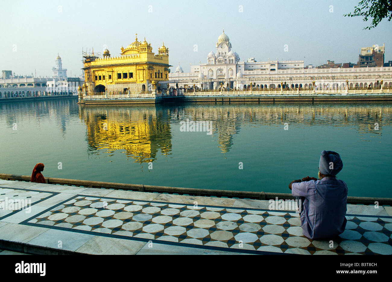 L'Inde, Punjab, Amritsar. Un pèlerin Sikh fait une pause de réflexion de l'Amrit Sarovar, la piscine d'Immortality-Giving 'Nectar', et le Temple d'or. Banque D'Images