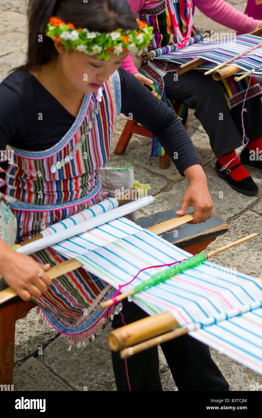L'Asie, la Chine, la Province du Yunnan. Sangle arrière-tissage pratiqué par les jeunes des minorités Dulong femme en costume ethnique traditionnelle. Banque D'Images