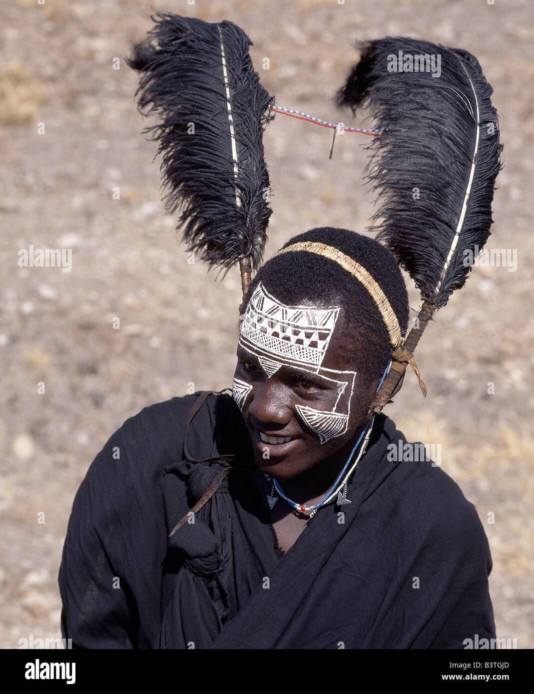 La Tanzanie, le nord de la Tanzanie, Kitumbeine. Les vêtements noirs, plumes d'autruche noir et blanc les motifs sur la face de Banque D'Images