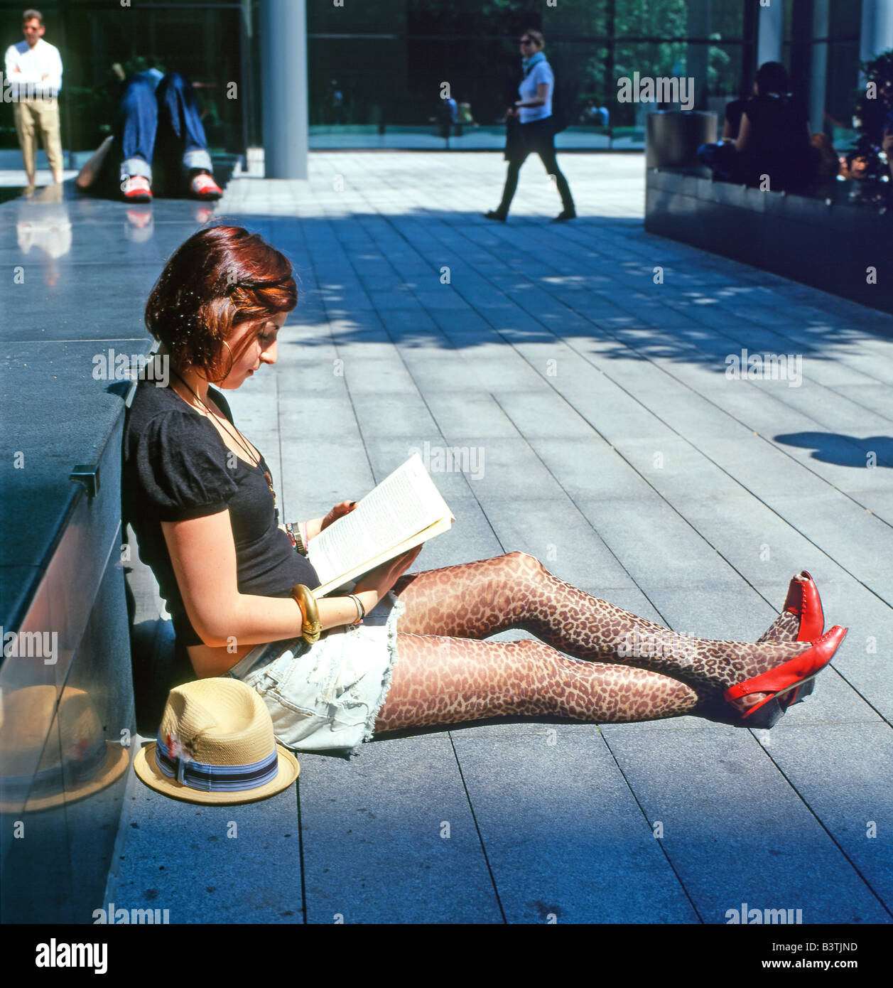 Une jeune femme portant des chaussures rouges assis sur les trottoirs de la  rue reading book évêques Square Spitalfields East London England UK KATHY  DEWITT Photo Stock - Alamy
