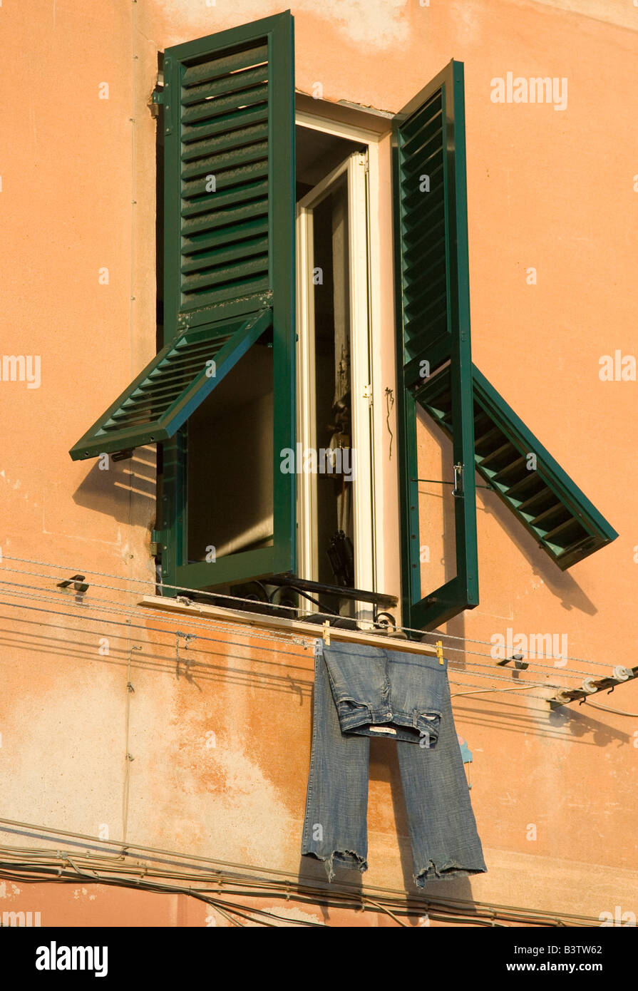 L'Europe, Italie, Camogli. Fenêtre à volets vert et bleu jeans sur corde à linge. Banque D'Images