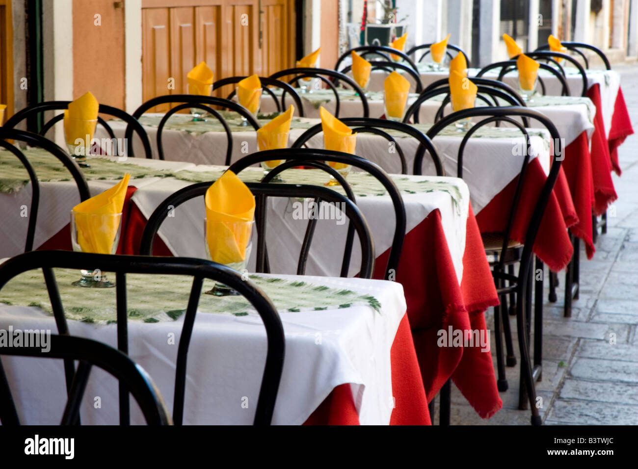 L'Europe, Italie, Venise. Une rangée de tables colorés à la terrasse d'un café. Banque D'Images