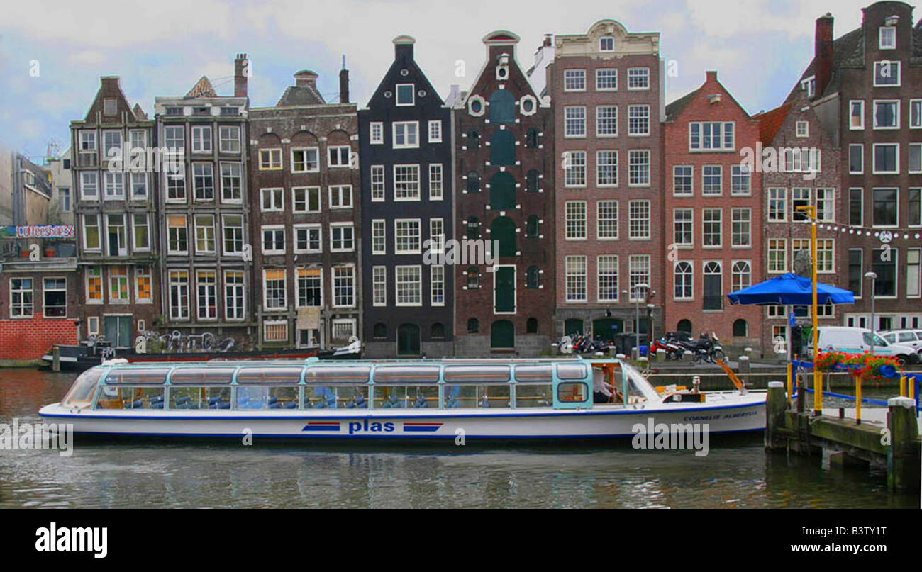 Un bateau d'excursion en attente à Rederij Plas dock sur un canal bordé de maisons à pignons colorés Banque D'Images