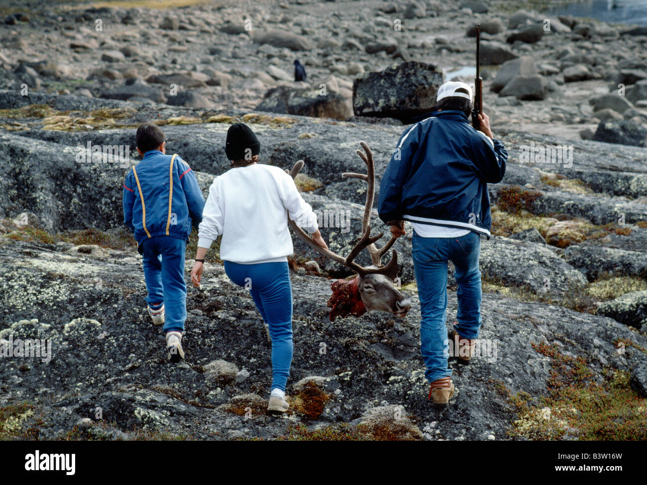 Les jeunes Inuit (Esquimau) COUPLE TRANSPORTANT LA TÊTE ET BOIS D'UN CARIBOU tourné récemment Banque D'Images