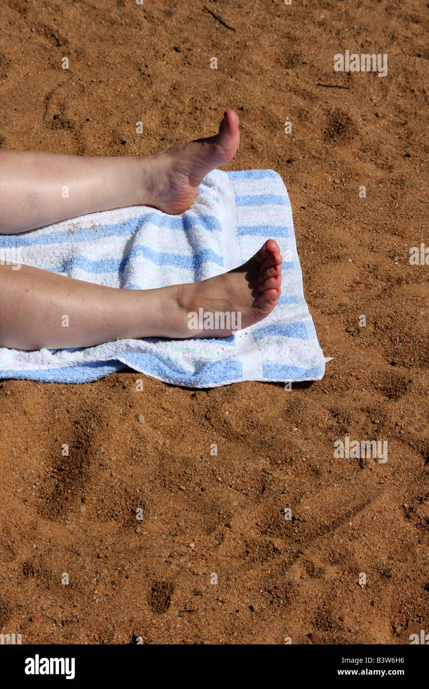 Mesdames les jambes et pieds de bronzer sur une plage Photo Stock Alamy