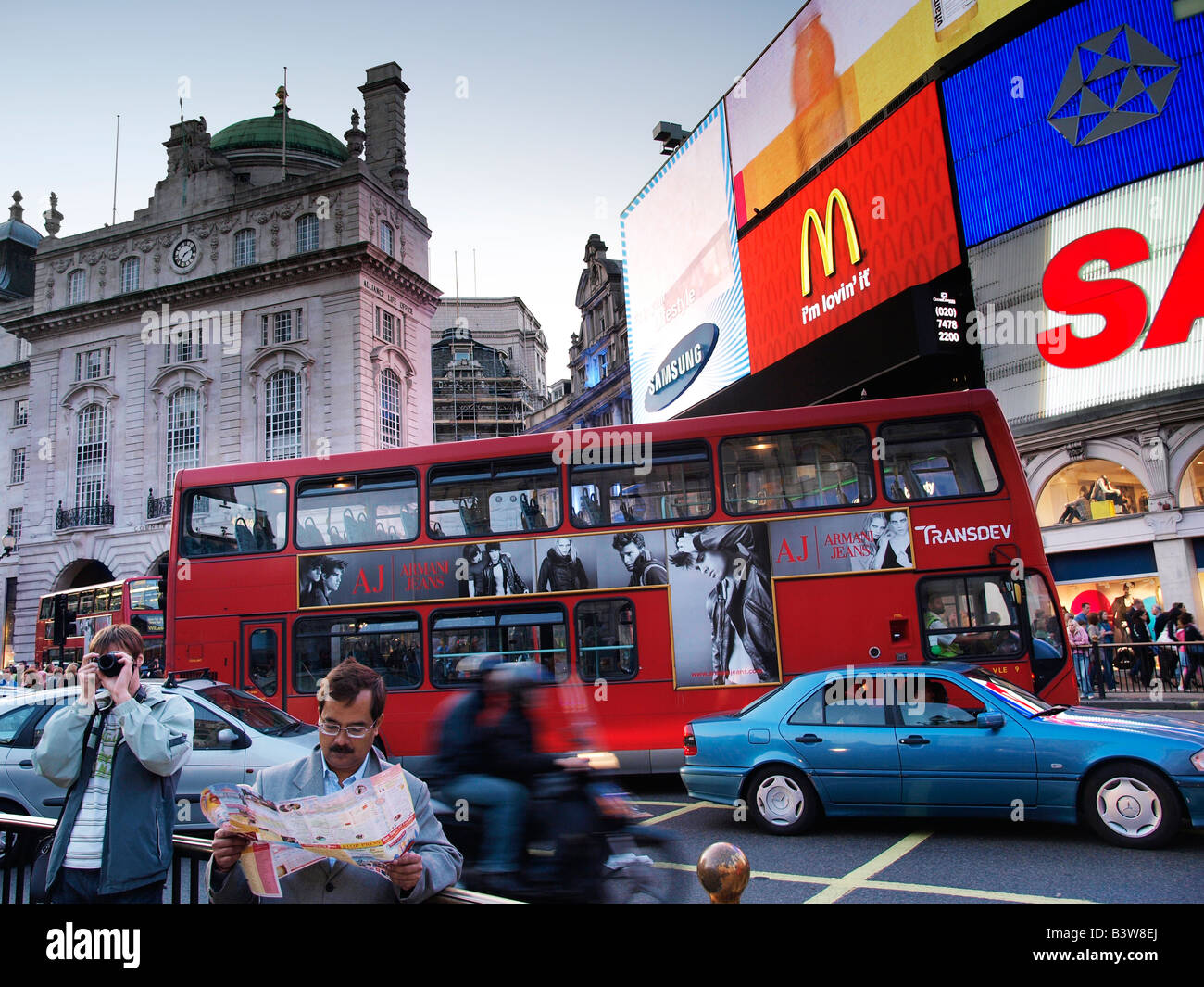 Piccadilly Circus London UK avec l'homme à la carte et de l'homme prenant photo Banque D'Images
