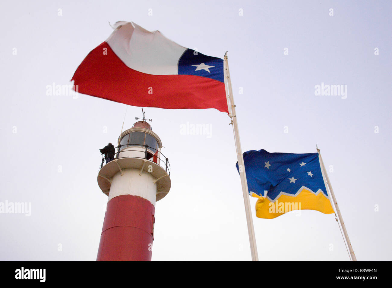 L'Amérique du Sud, Chili, Terre de Feu, l'île de Magdalena. Le phare de San Isidro avec drapeaux chiliens et la région de Magallanes. Banque D'Images