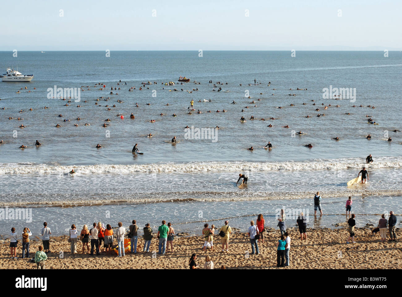 Les participants à une tentative de record de bienfaisance de surfers chaîne de bras liés 285 surfers Swansea Bay Banque D'Images