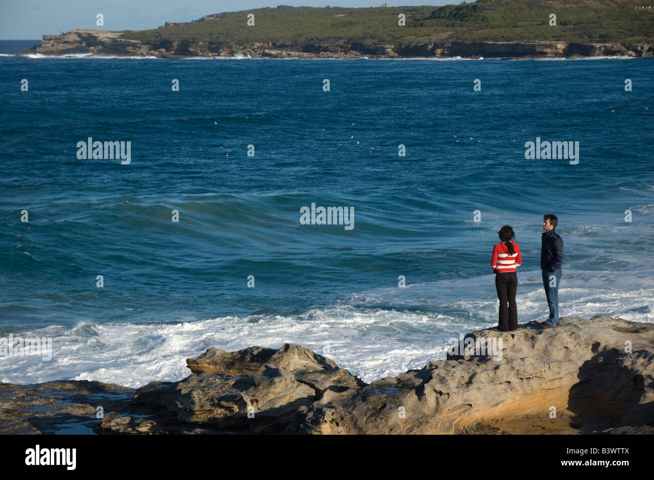 Un jeune couple regardant l'océan puissant Banque D'Images