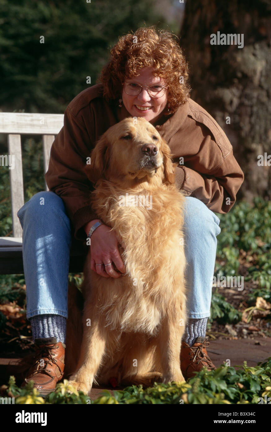 Portrait de femme d'âge moyen et son chien Golden Retriever. La femme prend le chien pour visiter les enfants malades comme une forme de thérapie Banque D'Images