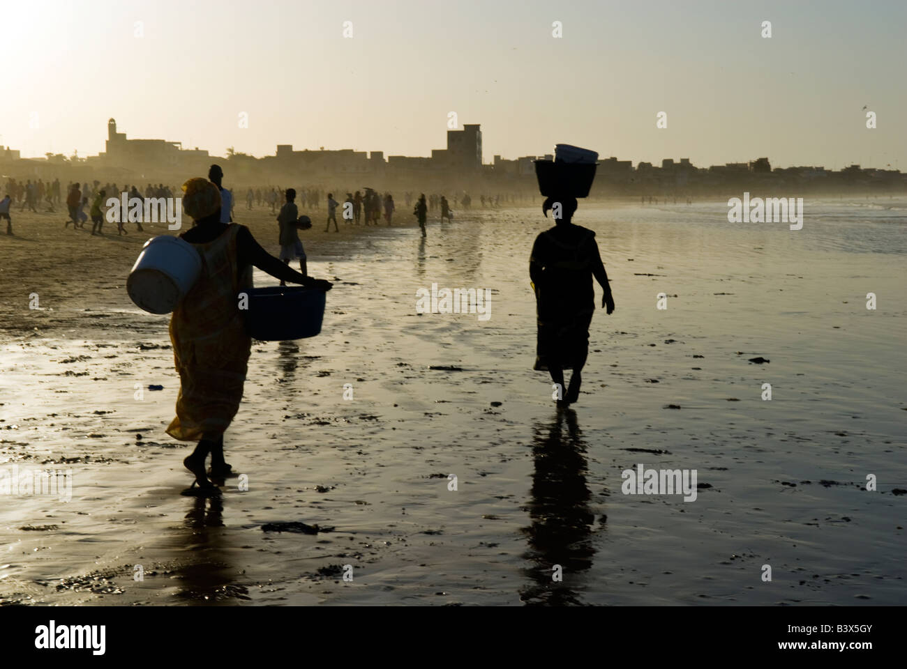 Deux silhouettes de femmes africaines marchant sur la plage près de Dakar, Sénégal. Banque D'Images