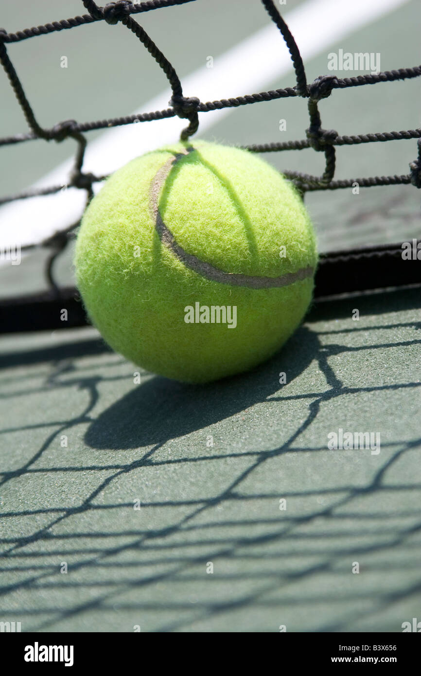 Close up de balle de tennis à la base du filet noir usé de cour vert Photo  Stock - Alamy