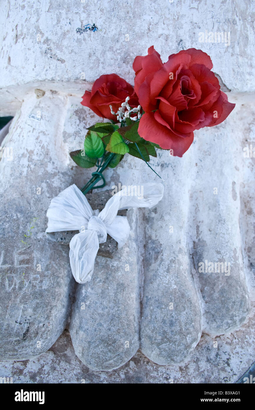 Une rose rouge en plastique entre les orteils de Nuestra Señora de Belen Belen une statue dans une petite ville dans la province argentine de Catamarca Banque D'Images