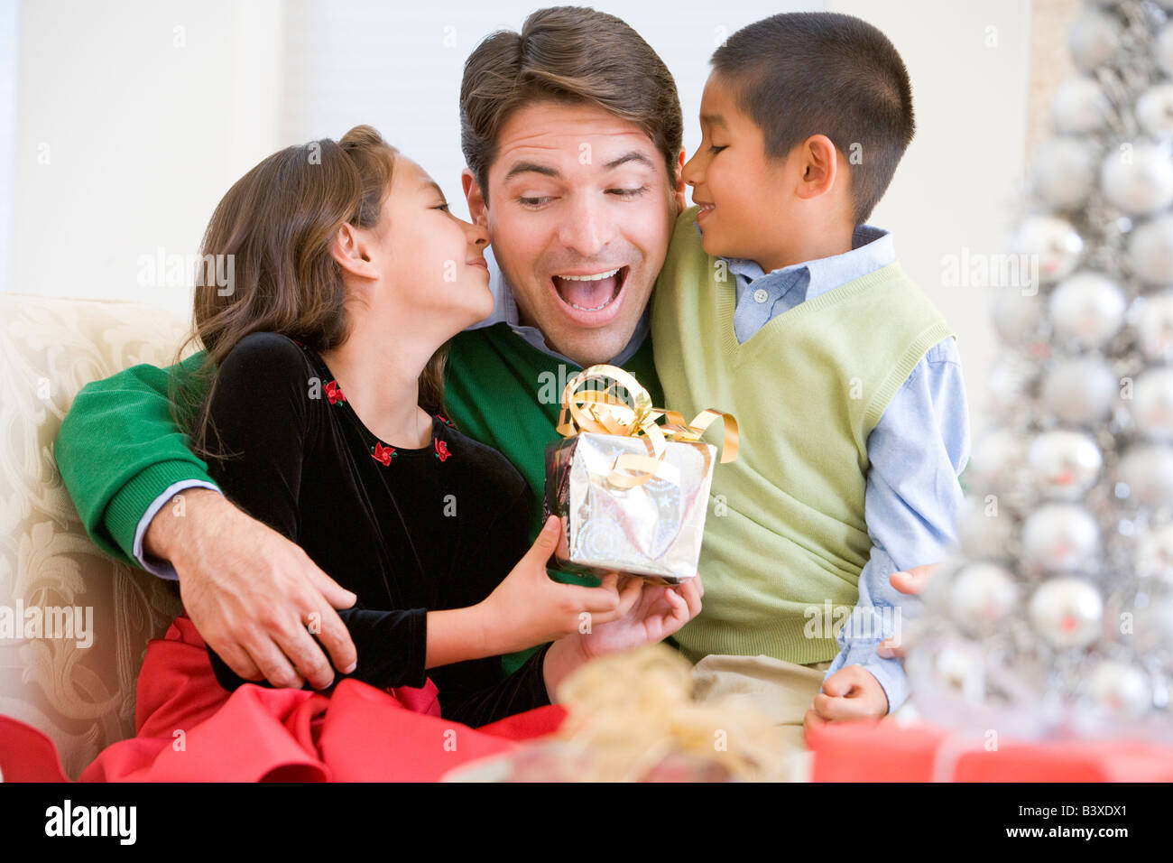 Père Étant donné un cadeau de Noël par sa fille et fils Banque D'Images