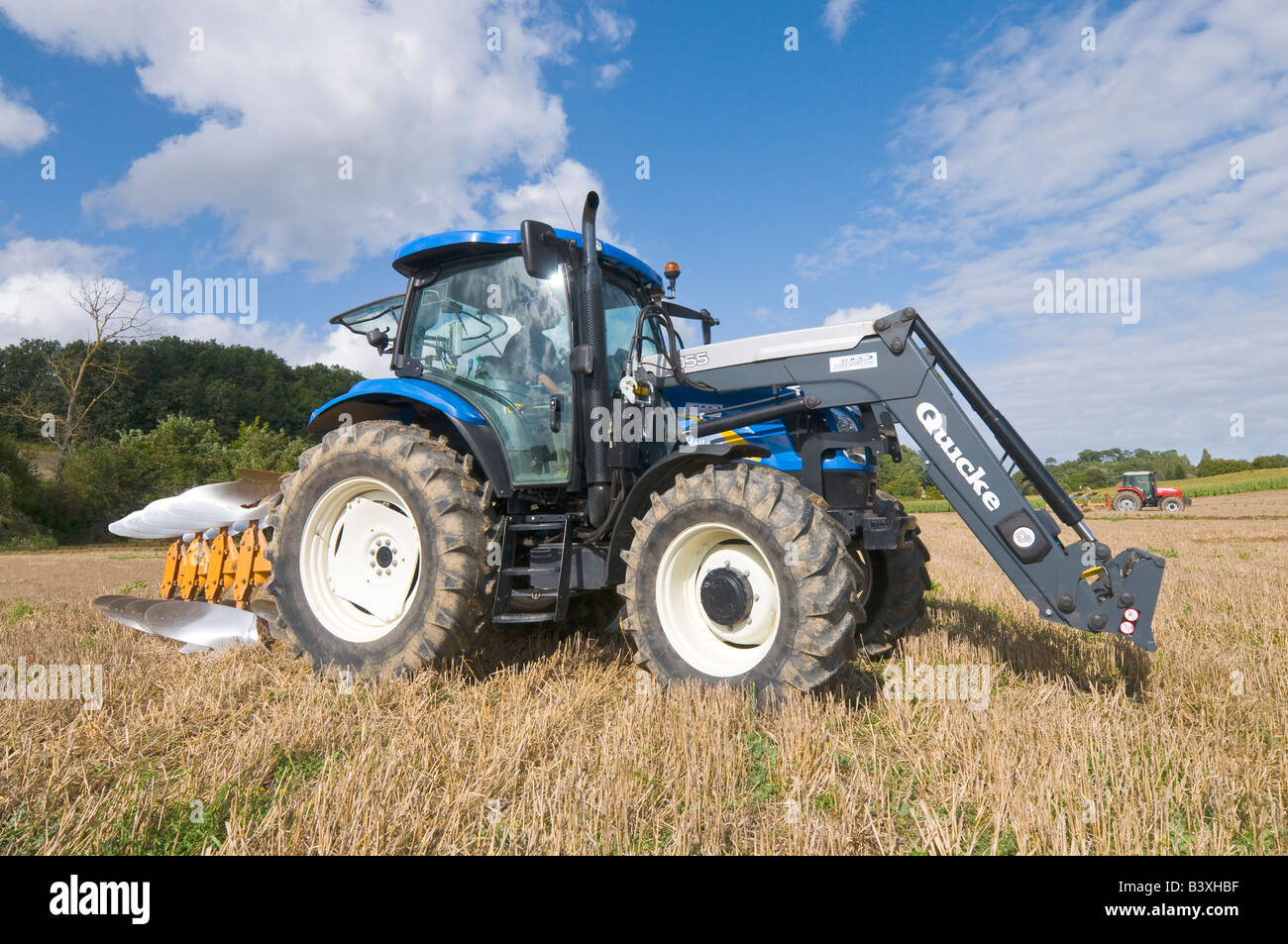 Tracteur New Holland avec Quicke releveur de ballots de paille de labour, Indre-et-Loire, France. Banque D'Images